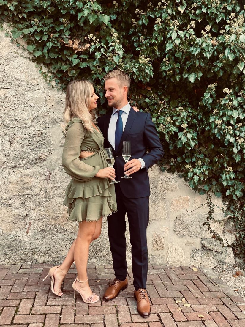Nadine und Fabian mit Sektgläsern an der Efeumauer